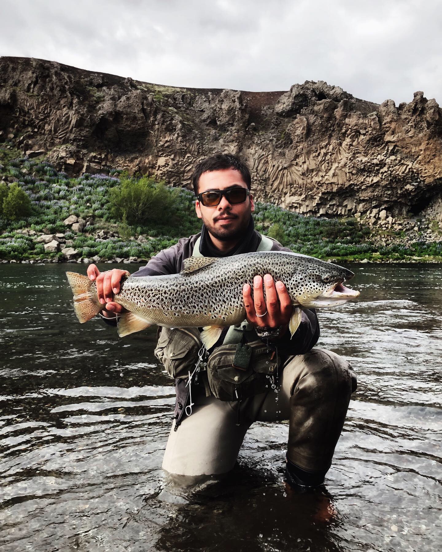 homme tenant une truite de mer lors d'une partie de pêche sur le circuit des perles du sud en Islande