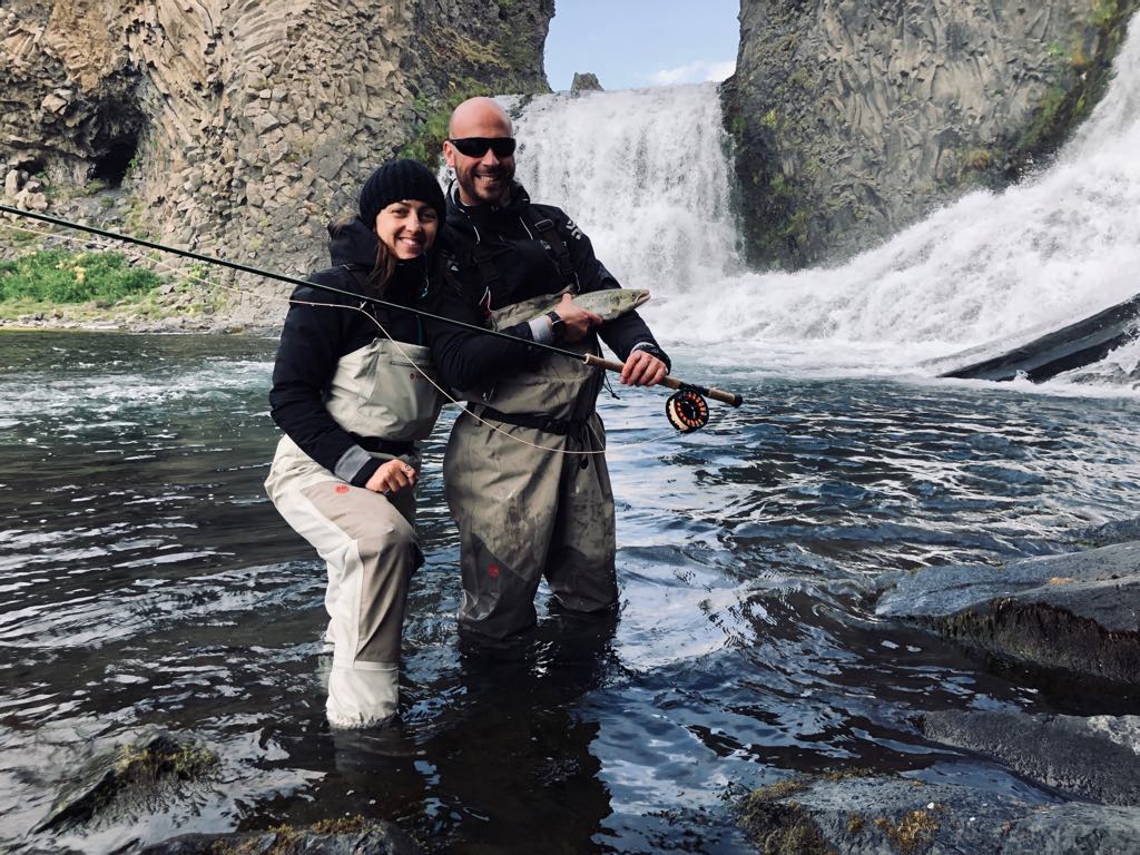 Un couple tenant un saumon lors d'un tour de pêche à la journée en Islande