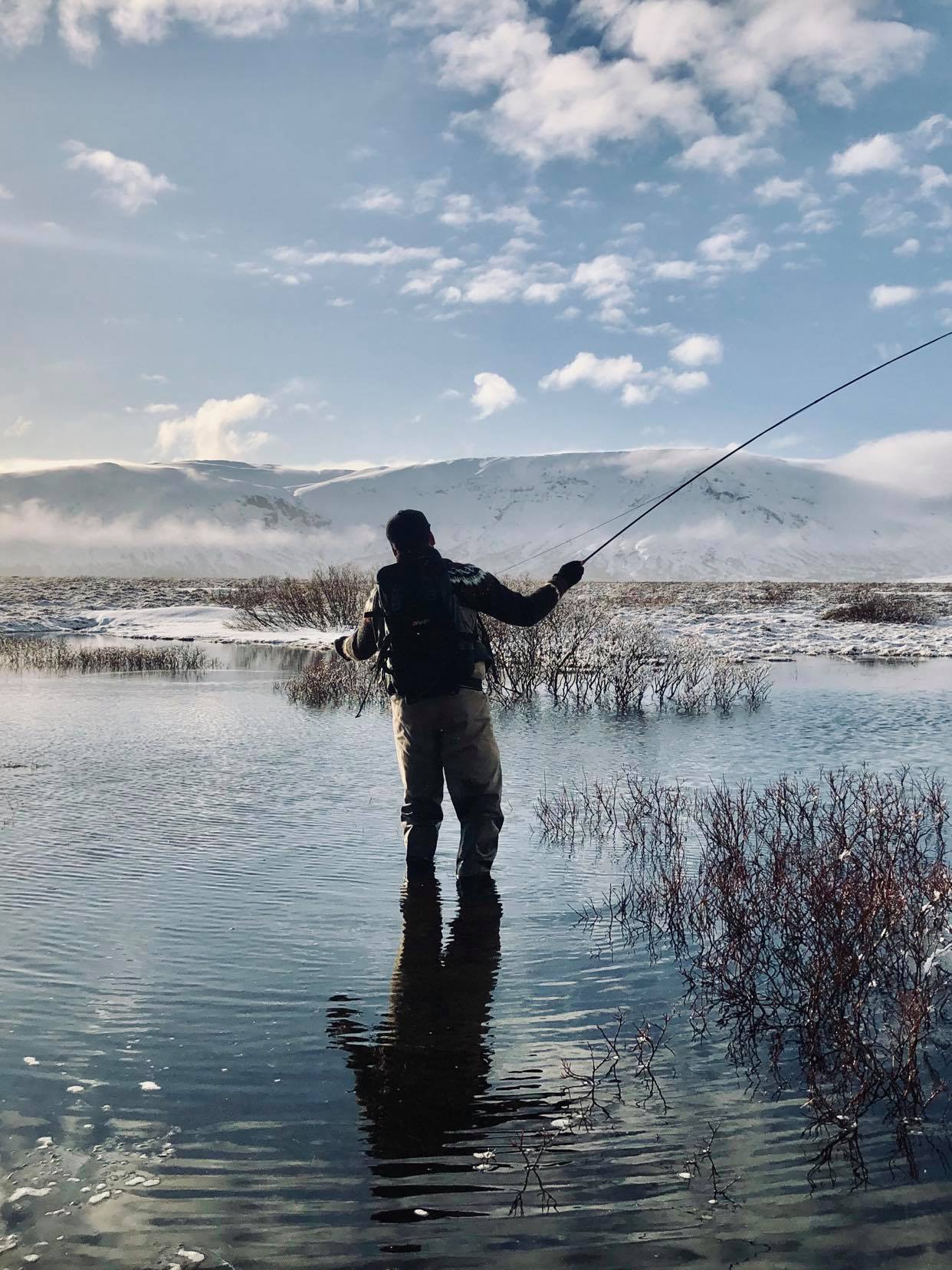 homme pêchant dans un paysage enneigé en Islande