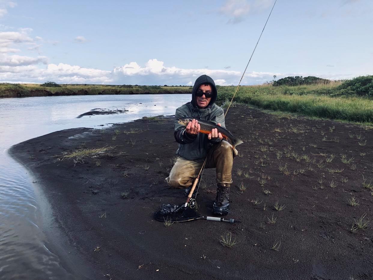 pêcheur tenant un omble arctique lors d'une journée de pêche dans les perles du sud en islande