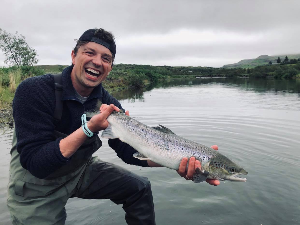 homme tenant un saumon en islande