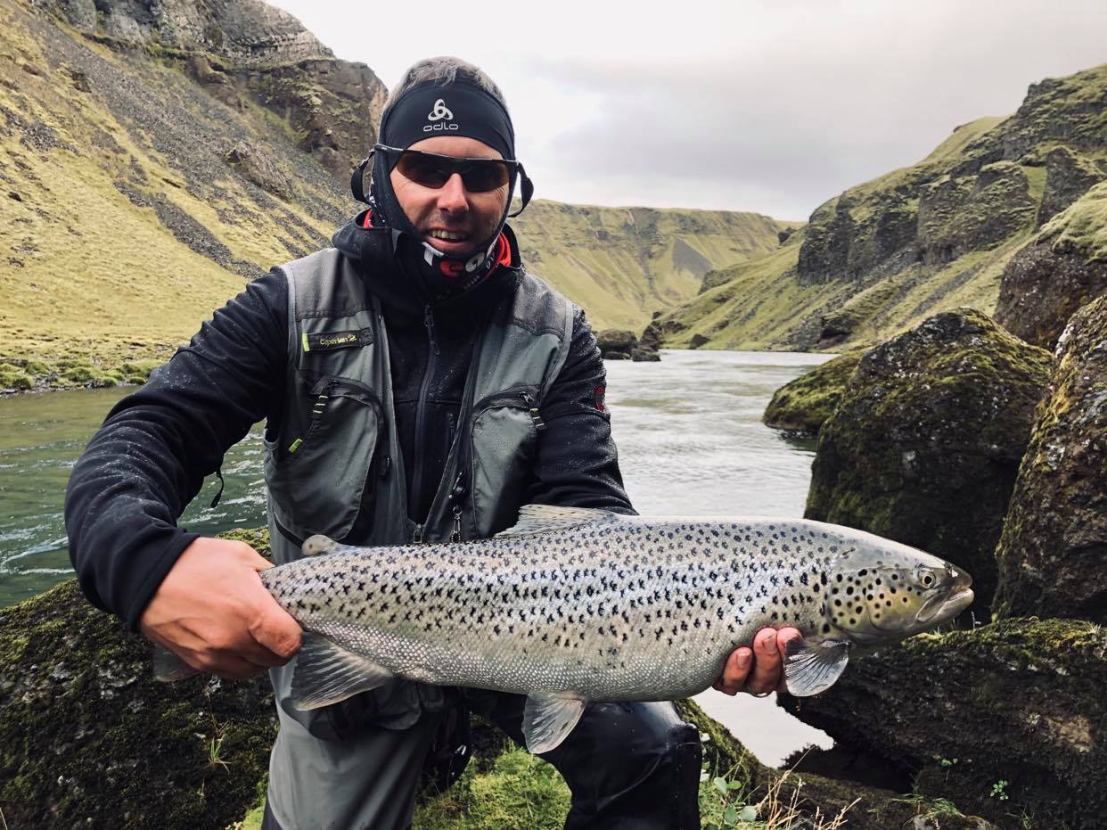 homme tenant une truite de mer sur la rivière Geirlandsá en Islande
